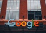 Colorful Google logo on modern building exterior in urban environment.