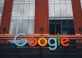 Colorful Google logo on modern building exterior in urban environment.